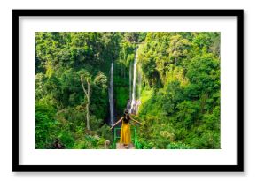 Young Asian woman traveler enjoying at Sekumpul waterfall the tourist destination in Bali, Indonesia