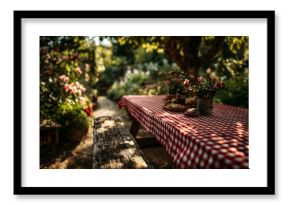 Wooden table with red gingham cloth in a lush garden ready for a summer barbecue