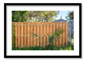 Wooden picket fence on green lawn surrounding property grounds for backyard protection and privacy