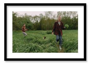 Middle age woman walking outdoors in green field holding fresh vegetables, promoting active and healthy lifestyle, wellbeing, fitness, and community connection.