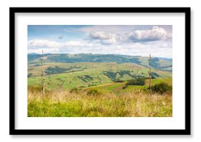 mountainous countryside landscape on early autumn forenoon. volovets district of transcarpathia, ukraine. sunny day with clouds on the sky. wooden poles