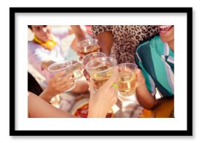 Group of friends toasting with beverages in an outdoor celebration showcasing bonding and joy