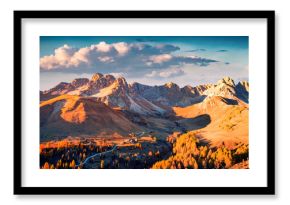 Breathtaking autumn scene of Fuchiade valley. Impressive evening view of Dolomite Alps, Italy, Europe. View from flying drone of golden larch trees forest at the foot of huge peaks.