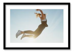 A Dynamic Jumping Woman Exuding Energy Against a Beautifully Clear Sky Above Her