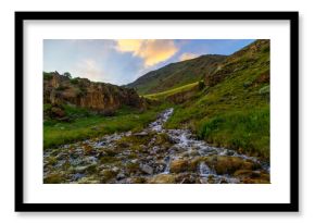 Serene stream flowing through rocky mountainous region in Kyrgyzstan