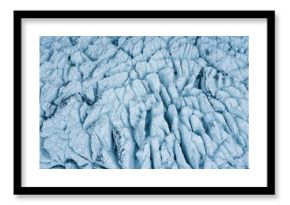 Aerial close-up of icy glacier surface showcasing abstract patterns and natural textures in a winter landscape