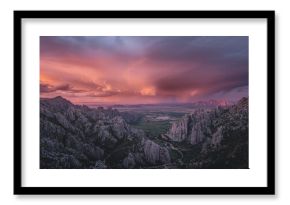 Approaching tempest looming above serene, rugged mountain landscape at dusk