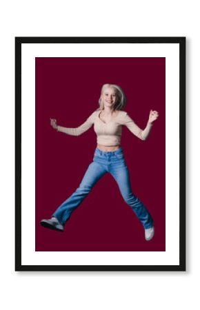 An Energetic Young Woman Joyfully Jumping Against a Vibrant Burgundy Background Canvas