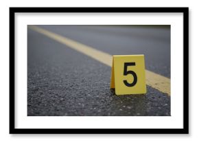 Yellow evidence marker number 5 placed on wet asphalt road, indicating a specific point of interest during a crime scene investigation or forensic analysis