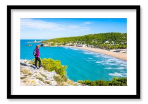 Female tourist at scenic viewpoint overlooking the Adriatic coast and golden beach near Peschici, Apulia, Italy