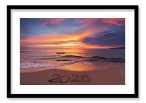 Scenic sunrise over the sea horizon and beach text Happy New Year 2026 on the sand