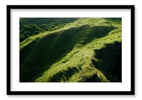 Aerial quadcopter view of a gentle mountain slope covered with grassy terraces forming soft waves in the landscape, creating a peaceful natural pattern with smooth elevation lines.