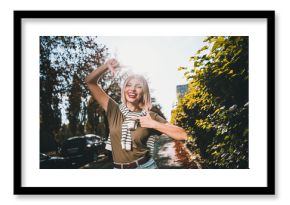 Photo of attractive young cheerful lady show frame fingers wear khaki garment tied shoulders sweater having fun outside outdoors