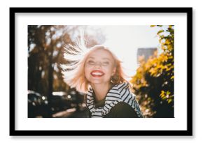 Photo of attractive young cheerful lady fluttering hair smile wear khaki garment tied shoulders sweater having fun outside outdoors