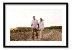 Farm, walking and holding hands with senior couple, love and relationship with vacation for honeymoon. People, outdoor or dirt road with old man, mature woman and countryside with romance or marriage