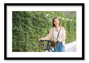 Lifestyle Asian young woman walking alongside with bicycle on summer in countryside outdoor, Happy female smiling walk down the street with her bike on city road, ECO environment, healthy travel