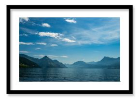 Alps mountain background. Swiss Alps mountain on sunny day. Mountain under clouds in blue sky. Blue nature background. Blue lake with sky near blue mountain.