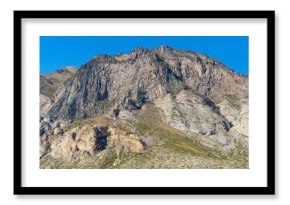 Dramatic mountain peak with rugged cliffs and rocky terrain, showcasing the raw beauty of barren landscape under clear blue sky. Kabardino-Balkaria, Chegemsky district