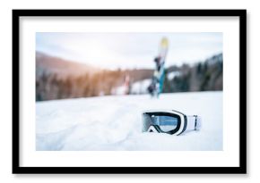 Close up of ski goggles in snow. Winter Alpine scenery with sport equipment.