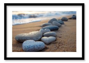 A collection of smooth, heart-shaped pebbles arranged on a sandy beach with gentle waves in the background, evoking a sense of gratitude for nature's beauty.