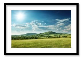 A breathtaking landscape featuring rolling green hills under a bright blue sky with fluffy clouds and a shining sun.