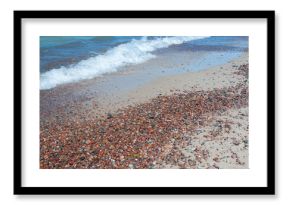 Pebbles and sand at seashore and sea waves
