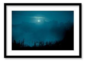 Night mystical scenery. Full moon over foggy river with reeds silhouettes on the foreground.
