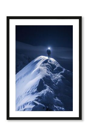 Mountaineer illuminated by headlamp walking on snowy ridge at night