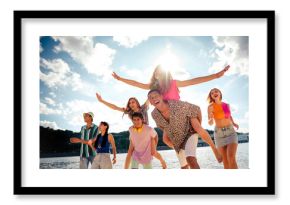 Fellows jumping enjoying a summer day by the water, embracing happiness and friendship outdoors during a sunny vacation