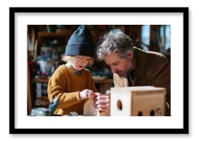 Grandparent and child bonding while building a birdhouse in a cozy workshop during sunny afternoon