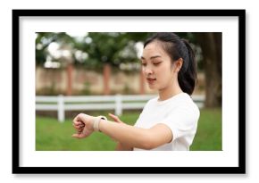 Fitness and Wellness. Young woman checking smartwatch while preparing for outdoor exercise.