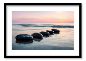 Serene sandy beach scene with smooth stones in water during sunrise or sunset.