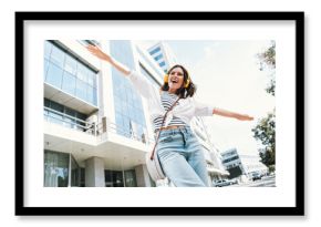 Joyful young woman in stylish outfit enjoying a sunny day outdoors in urban cityscape
