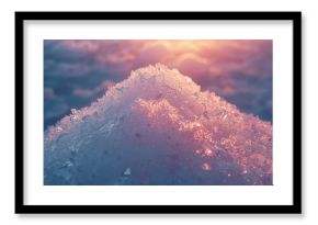 Glittering mound of translucent ice crystals reflecting warm sunrise glow on snowy ground