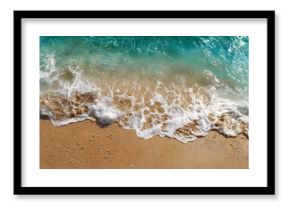 Aerial view captures foamy ocean waves washing onto a golden sandy shore