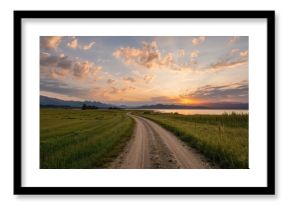 Sunset over a lakeside dirt path in a rural area
