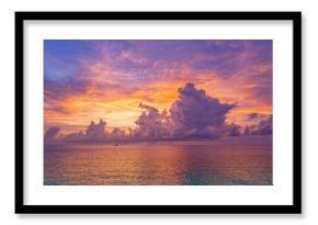 Vibrant sunset sky filled with dramatic clouds above the ocean, seasonal change