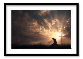 Man kneeling before cross at sunrise