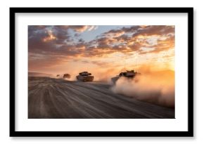 Military tanks driving through desert at sunset. Armored vehicle convoy moving in dust. Army training and combat operations concept.