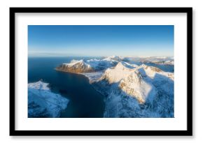 Flight over the mountains. Scandinavia. Aerial view on the Lofoten Islands, Norway. Wide panoramic view of the north. Natural winter landscape from air. Photo for postcards, backgrounds, wallpapers.