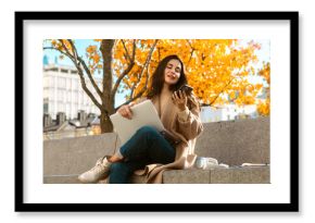 Woman Relaxing with Phone and Laptop in Autumn Park