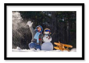 Kid dreaming of become a pilot in snow. Happy child holding plane imagining flight. Child playing pilot dream in winter. Child imagining to fly in winter. Child dreaming to flying. Kids pilot dream.
