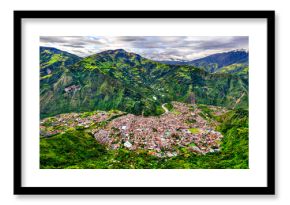 Panoramic aerial view of Banos de Agua Santa in Ecuador. Scenic landscape features town nestled in green Andean valley with Pastaza river below mountains