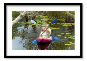 Happy Asian family senior couple kayaking in the river on summer holiday vacation. Healthy elderly people enjoy and fun outdoor active lifestyle travel nature, sport and rowing a boat in the lake.