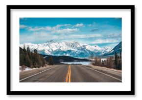 Road trip with on highway road with snow covered rocky mountains in winter at Kootenay plains area, Canada