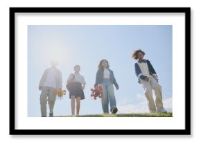 Low angle shot of multiracial teen in casual clothes carrying robots while getting down hill