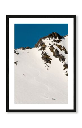 High angle view of a snowy mountainside where a splitboarder has descended on his splitboard