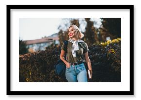 Photo of pretty young blonde woman wondered look walking wear khaki clothes tied shoulders sweater outside urban city park