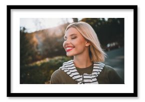 Photo of pretty young blonde woman dreamy smile wear khaki clothes tied shoulders sweater walk outside urban city park