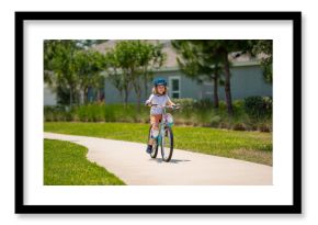 Kid riding bike in a helmet. Child with a childs bike and in protective helmet. Happy kid boy having fun in summer park with a bicycle. Bike helmet, bicycle safety, cycling accessories.